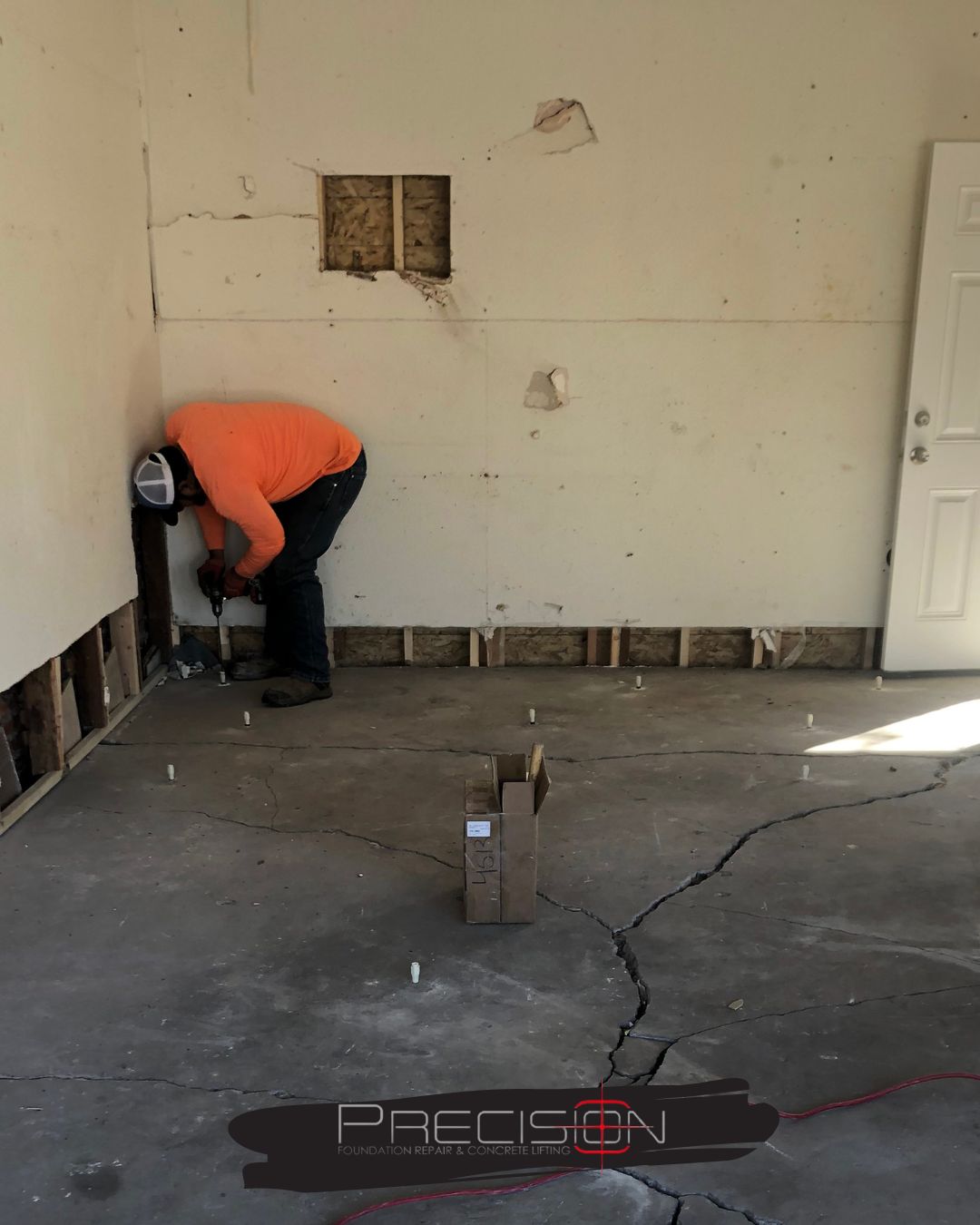 A Precision Foundation Repair crew member preparing to inject foam for a foundation stabilization project on a home in Eastland, Texas.